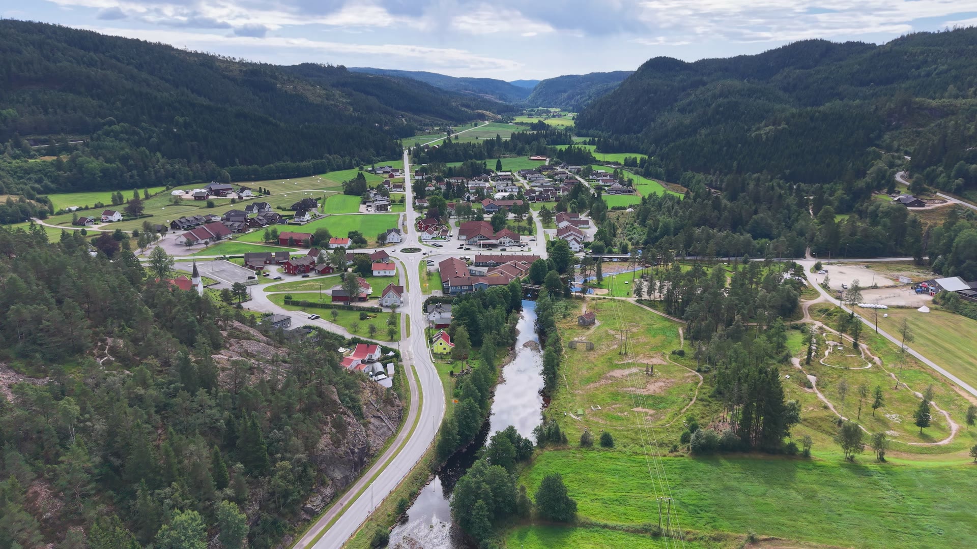 Konsmo sett fra lufta, med bygda, Audnaelva og skogkledde åser rundt