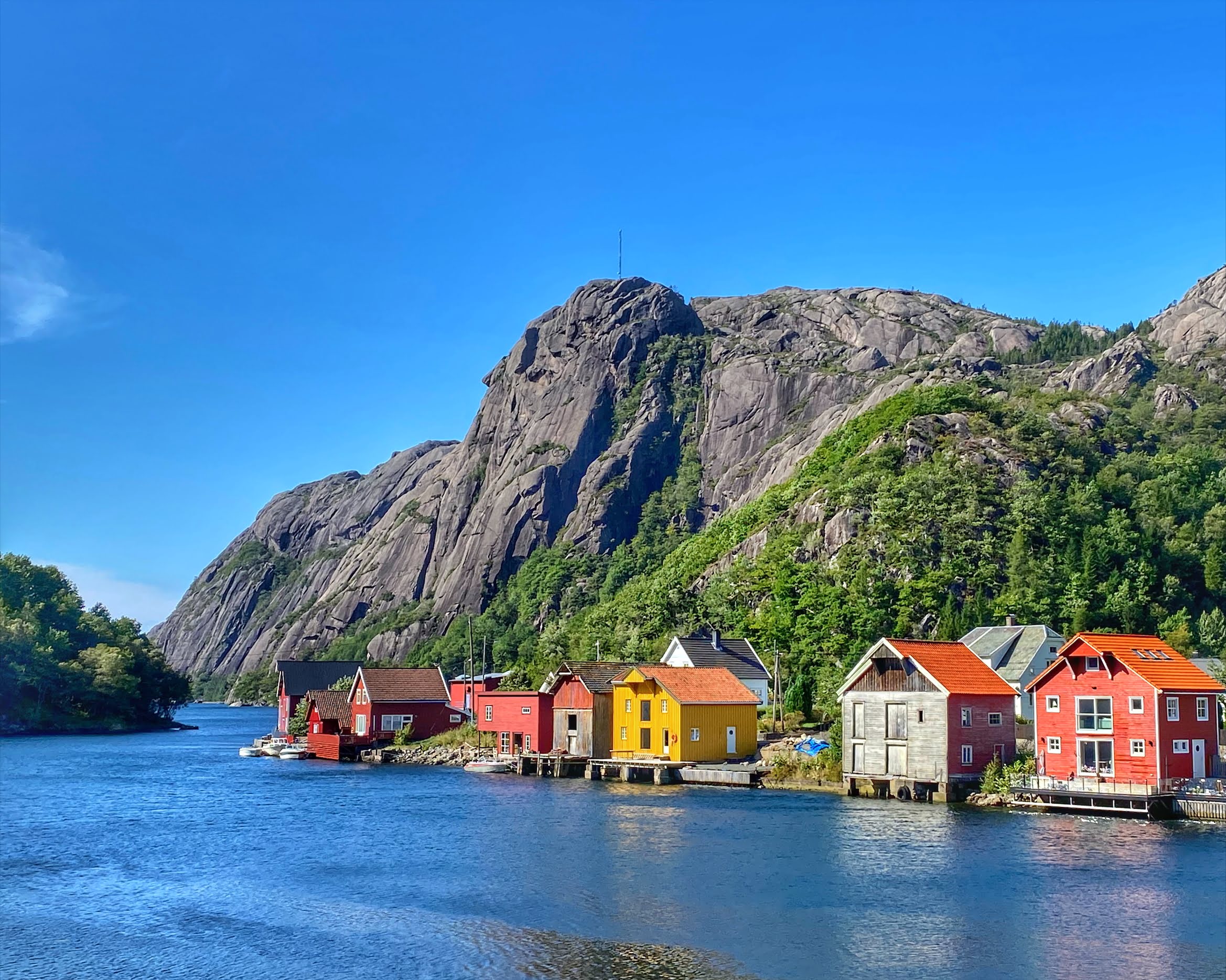 Flyfoto av Åna-Sira ved elva Sira, med hus på begge sider og fjellene rundt