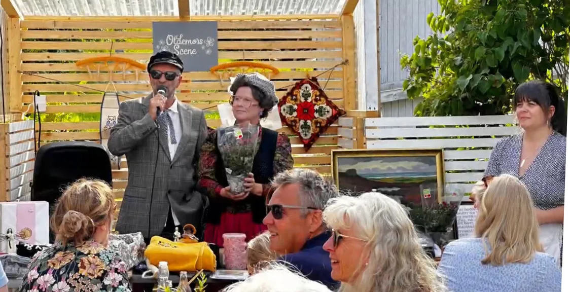 Sommerkveld i Oldemors hage med gjester rundt bordene