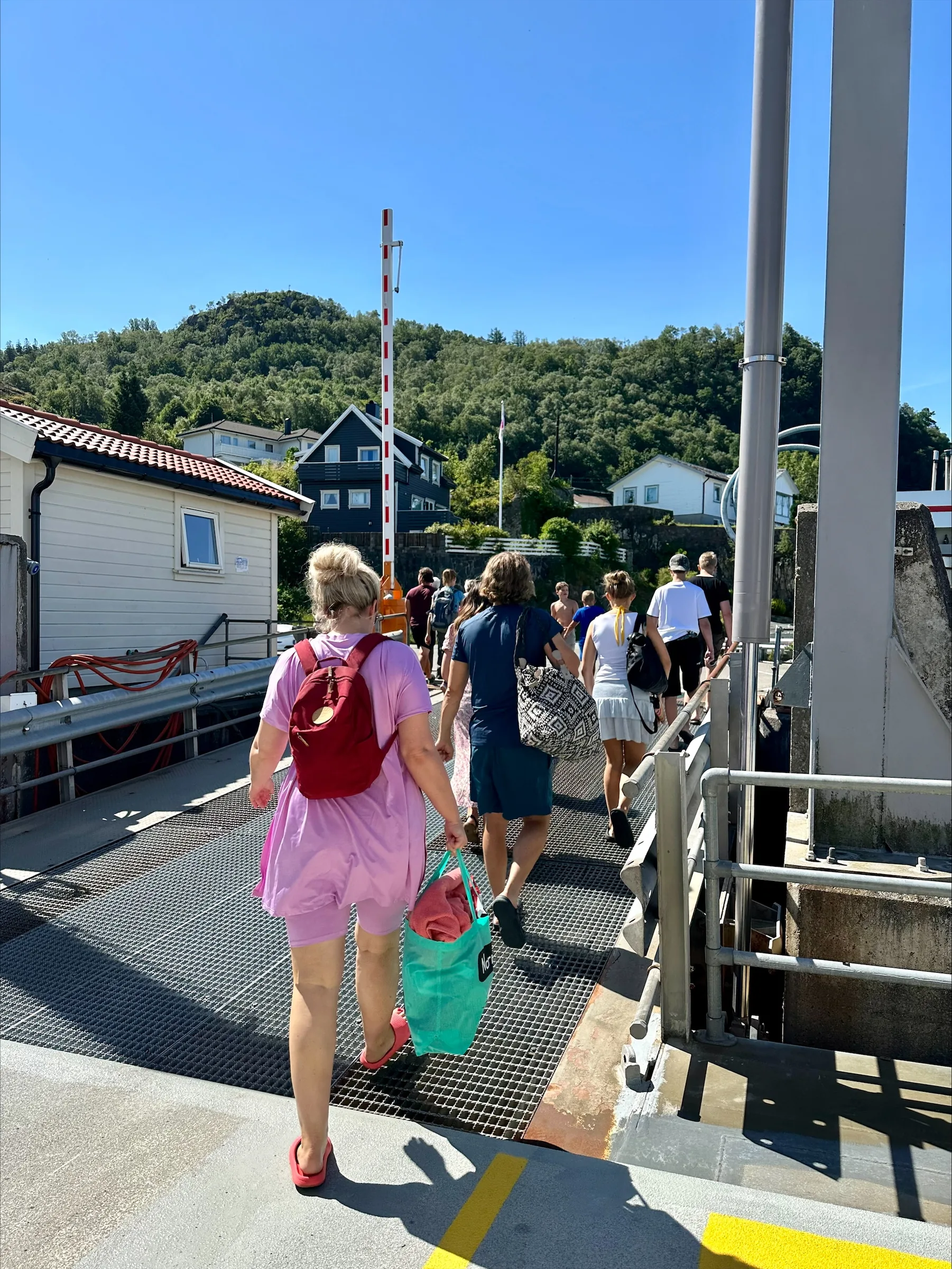 Folk går av ferja på kaia på Andabeløy en sommerdag