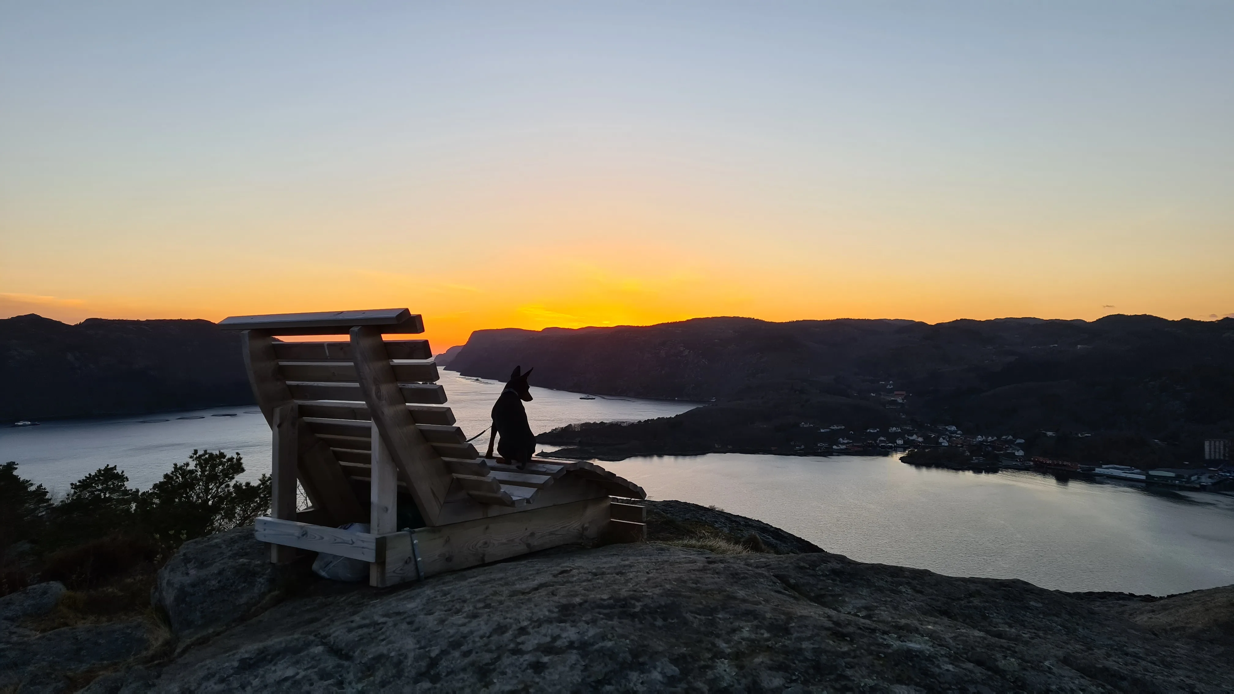 Utsiktsbenken på Nonknuten i solnedgang, med fjorden og åsene under