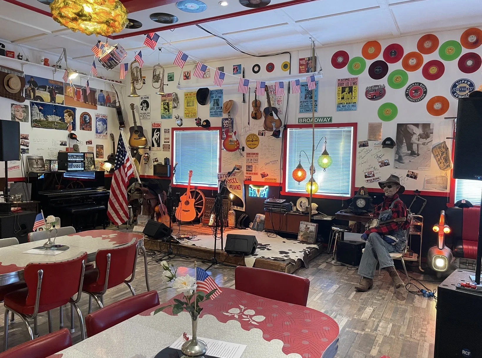 Konsertscenen i dineren, med amerikanske flagg, LP-plater og instrumenter på veggen