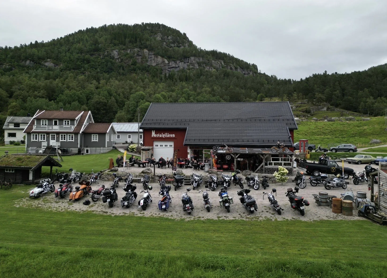 Rader av motorsykler parkert på gresset foran Nostalgilåven under «Cars & Bikes»