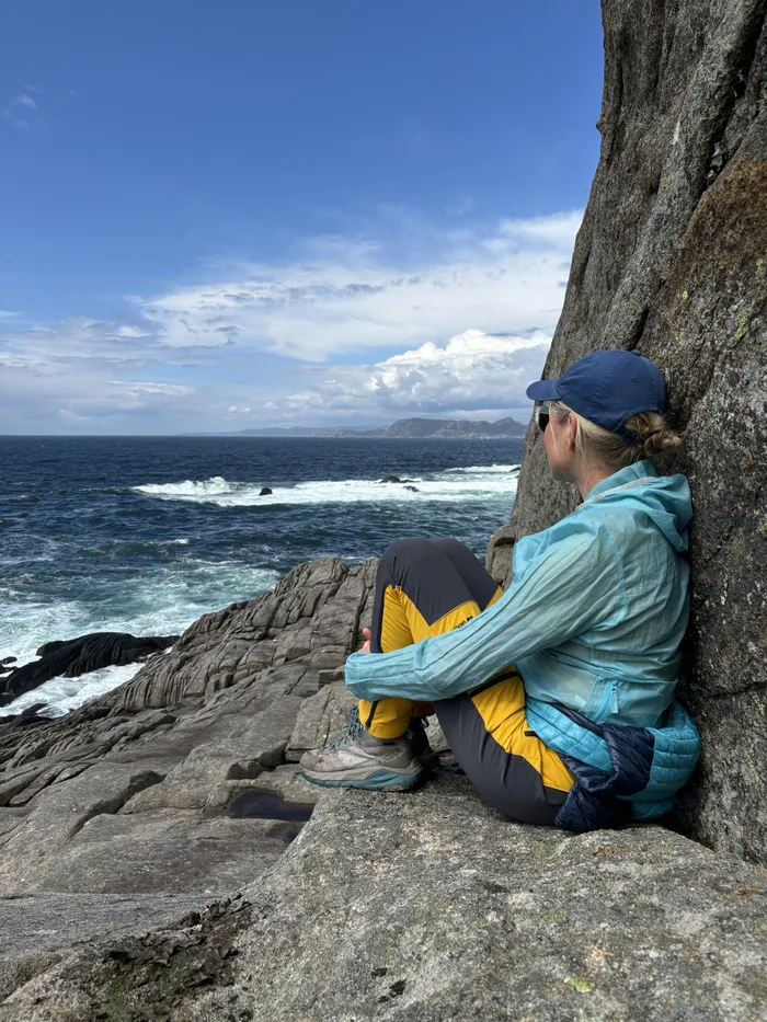 Mette Starheim Pedersen sitter på et svaberg og ser utover havet ved Farsund