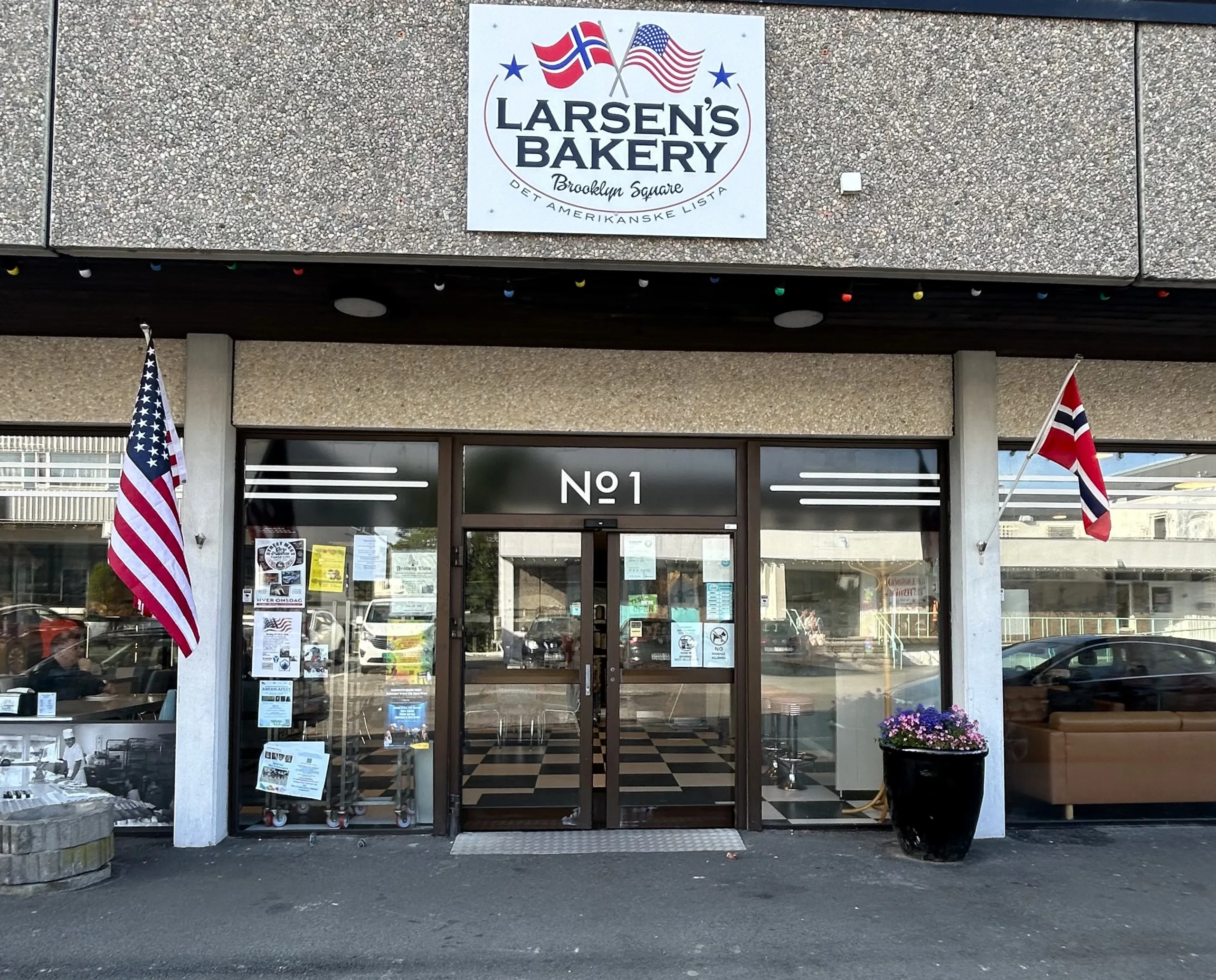 Inngangen til Larsens Bakery på Brooklyn Square, med norsk og amerikansk flagg på hver side