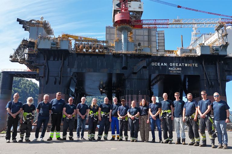 Ansatte ved Green Yards verft i Flekkefjord, med skip til kai i bakgrunnen