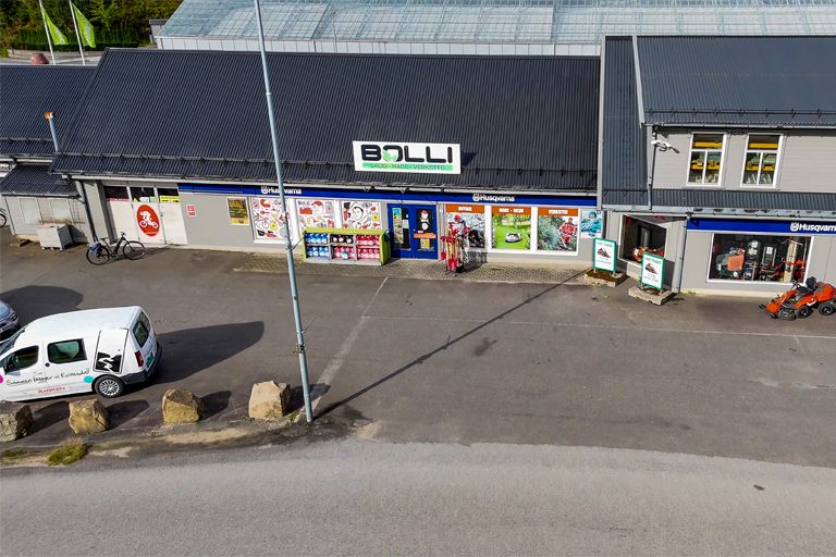 Fasaden til Bolli med skilt, utstillingsvinduer med utstyr og en Husqvarna-plakat, sett ovenfra