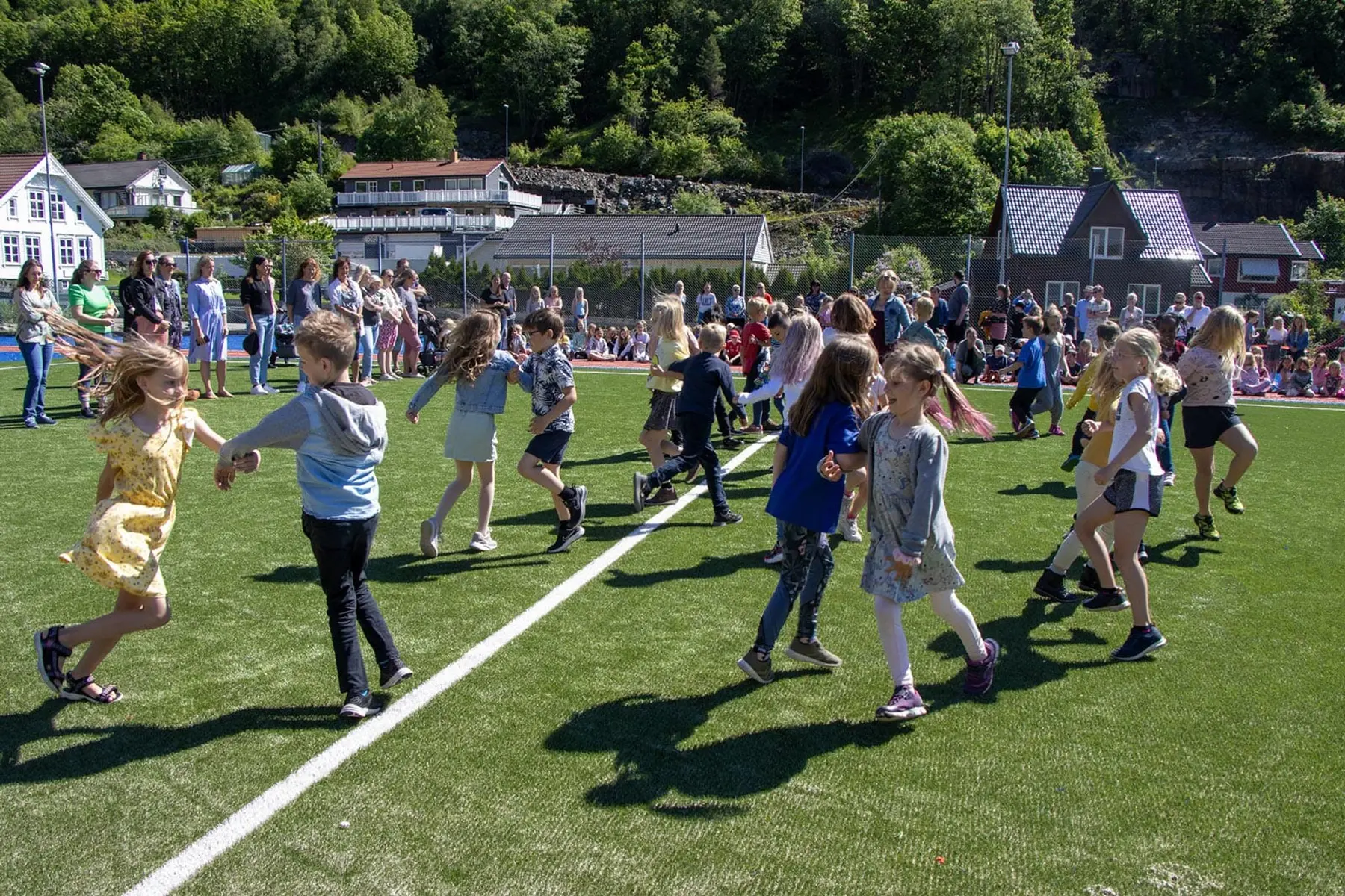 Barn i full fart over idrettsbanen ved Søyland skole