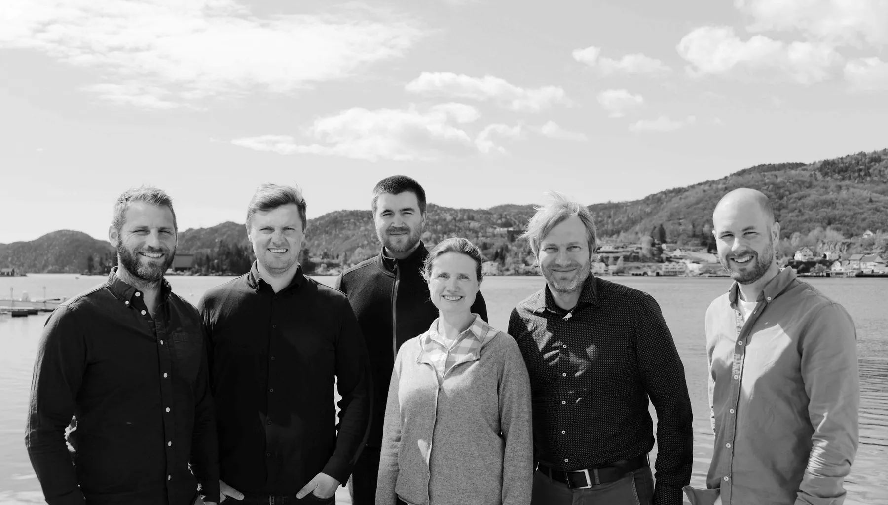De seks ansatte i Pilar Byggrådgivning står samlet ved sjøen i Flekkefjord