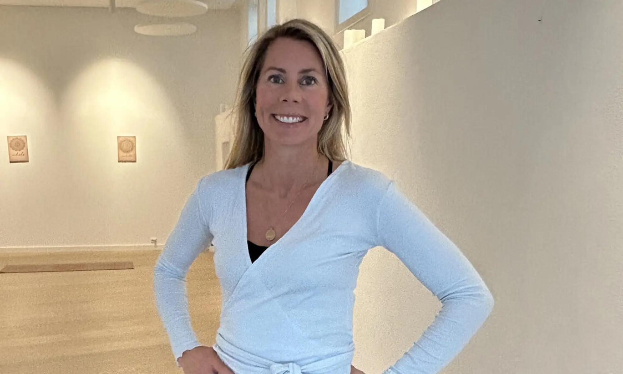 Nina Willumsen Moseidjord stands in her yoga studio, dressed in yoga clothes