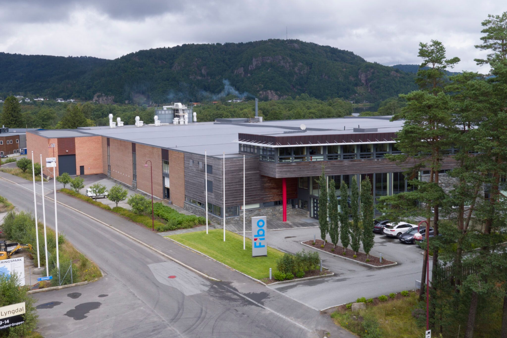 Fibos hovedkontor og produksjonsanlegg i Lyngdal sett ovenfra, med skiltet "Fibo" foran inngangen